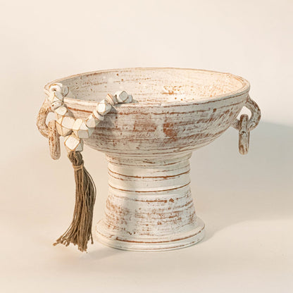 Handcrafted white bead garland draped over a rustic white ceramic bowl for modern boho home styling.