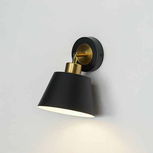 Closeup of black metal wall light with cone shade for modern bedroom hallway and living room decor styling.