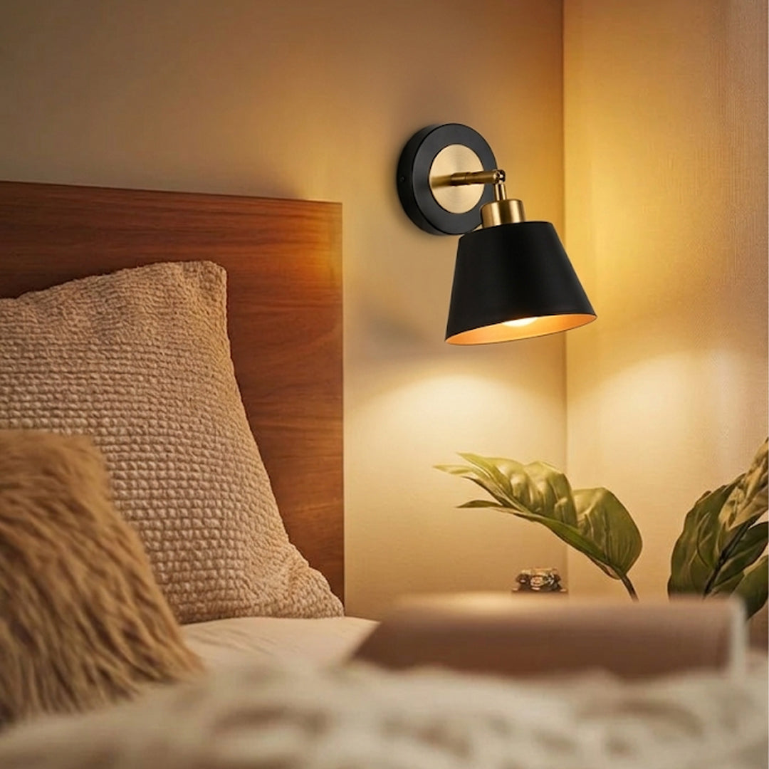 Modern black metal wall light glowing beside bed for cozy bedroom decor and ambient interior lighting styling.