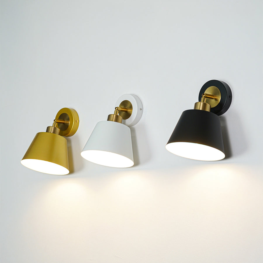 Set of wall lights with gold white and black cone shades emitting warm glow ideal for modern bedroom or hallway wall decor.