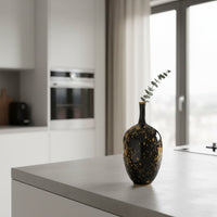 Black ceramic decorative vase styled with dried stems on a kitchen island for sophisticated modern home decor settings.
