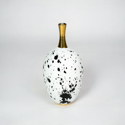 White ceramic vase with gold neck for stylish table placement and modern indoor home decor styling accent piece.
