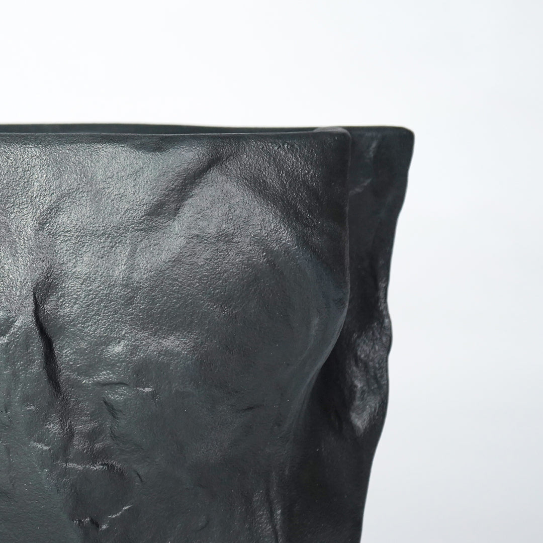 Closeup image of black ceramic textured planter vase for modern shelf decor styling with artistic matte finish display.