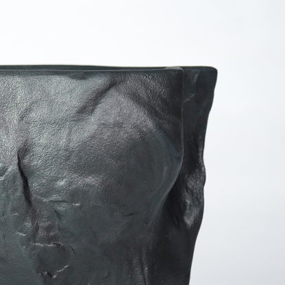 Closeup image of black ceramic textured planter vase for modern shelf decor styling with artistic matte finish display.