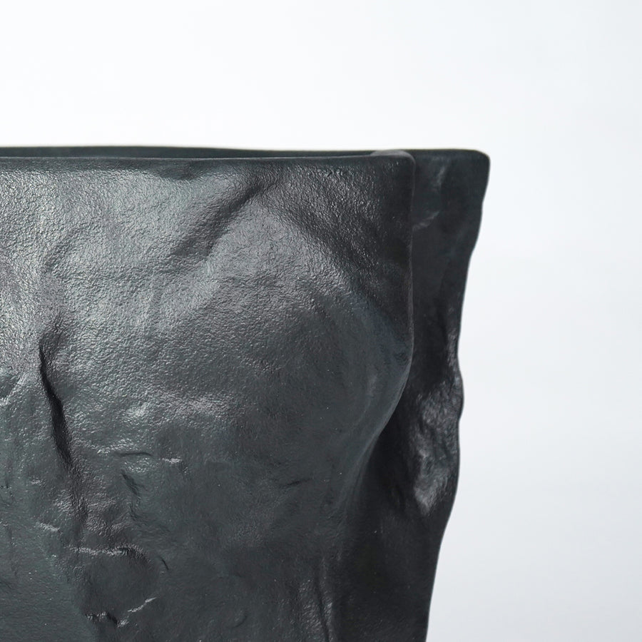 Closeup image of black ceramic textured planter vase for modern shelf decor styling with artistic matte finish display.