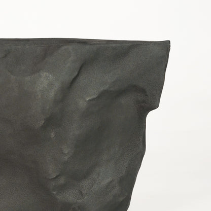 Closeup image of black ceramic textured planter vase for modern console table decor styling with matte finish.
