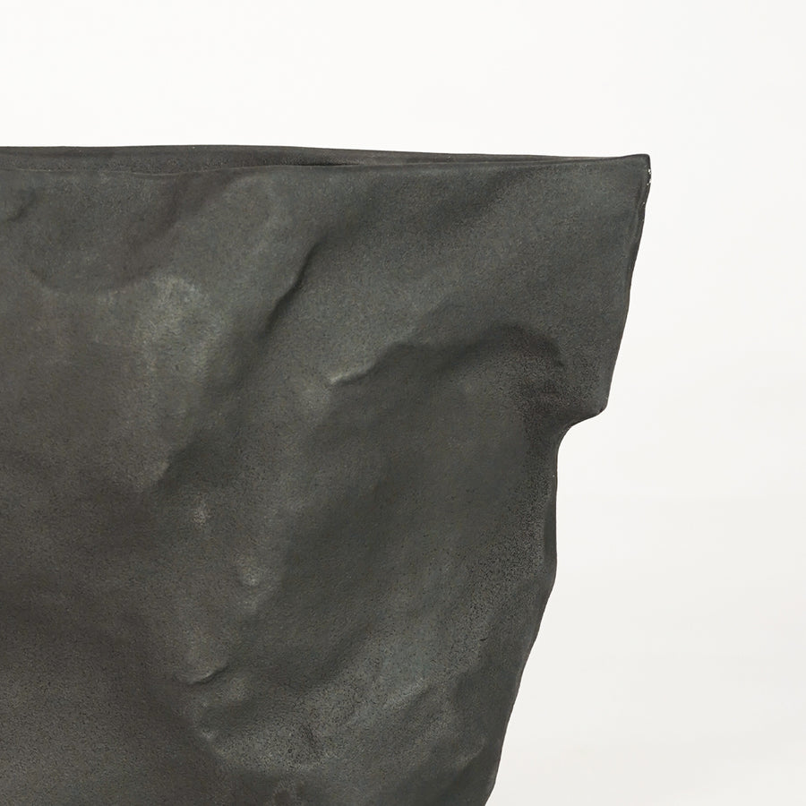 Closeup image of black ceramic textured planter vase for modern console table decor styling with matte finish.