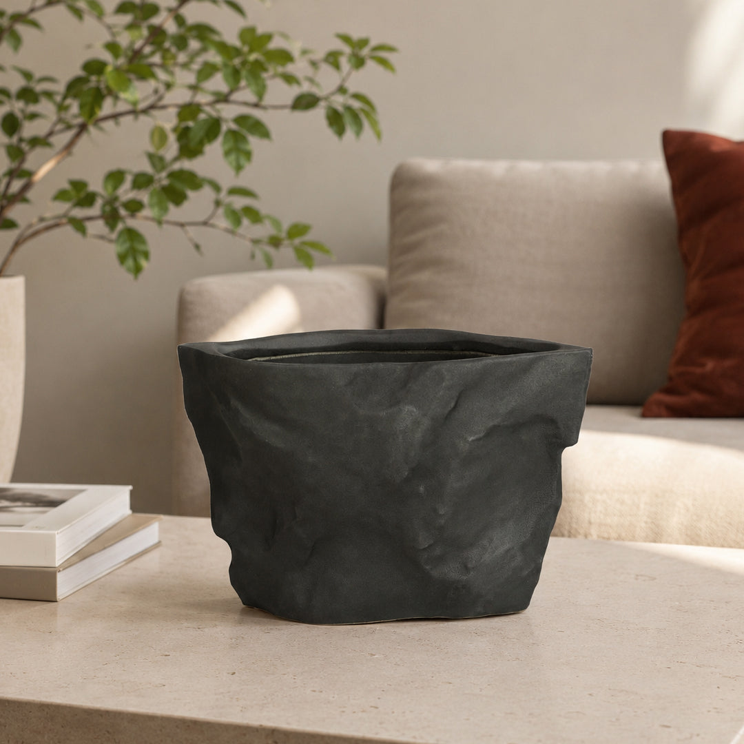 Closeup image of black ceramic planter vase for modern living room tabletop decor with artistic matte finish.