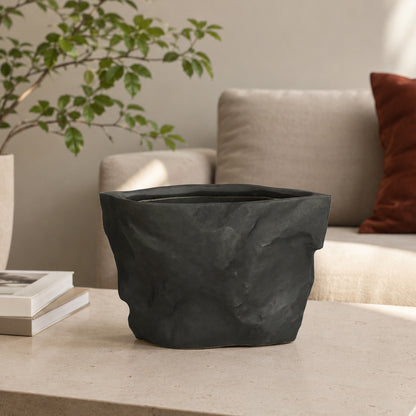 Closeup image of black ceramic planter vase for modern living room tabletop decor with artistic matte finish.