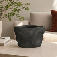 Closeup image of black ceramic planter vase for modern living room tabletop decor with artistic matte finish.