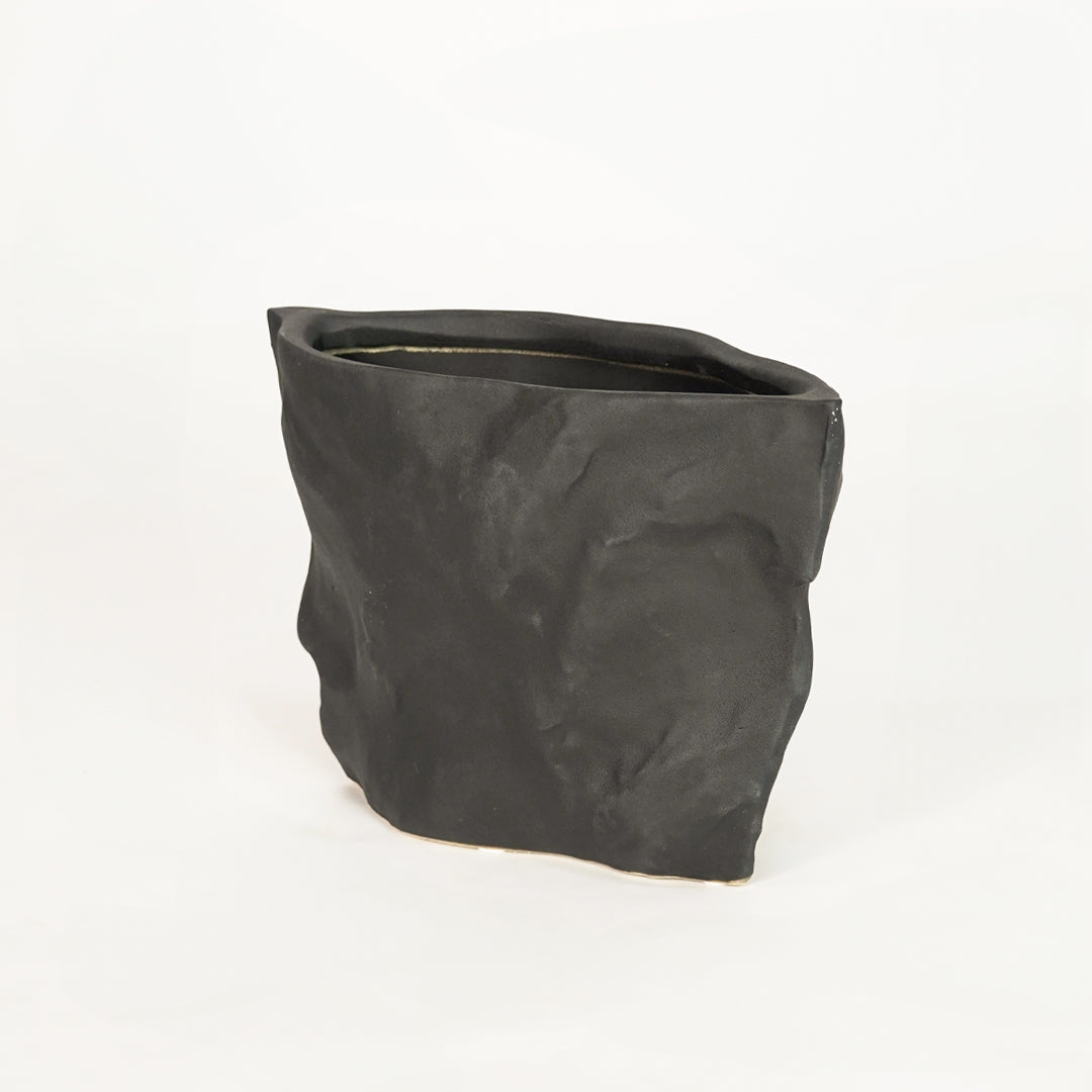 Closeup image of black ceramic planter pot for elegant tabletop decor styling with artistic matte textured finish.