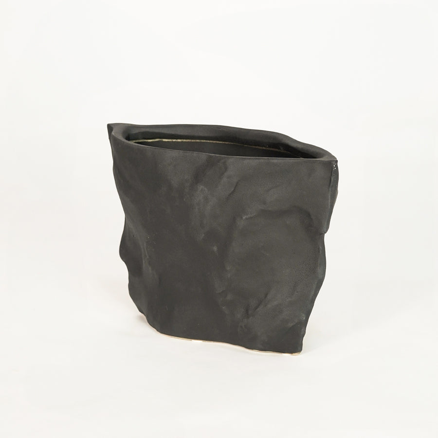 Closeup image of black ceramic planter pot for elegant tabletop decor styling with artistic matte textured finish.