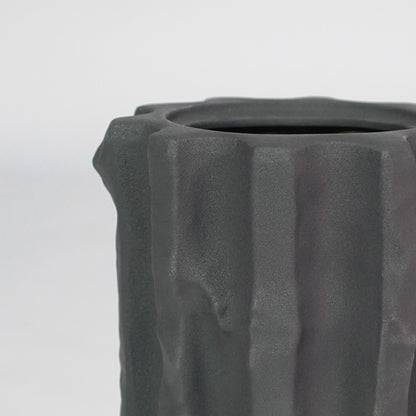 Closeup image of black ceramic planter vase for modern console table decor with artistic matte texture styling.