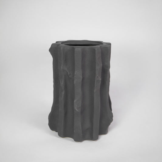 Black textured ceramic planter pot for modern indoor shelf placement and elegant home decor styling accent piece.