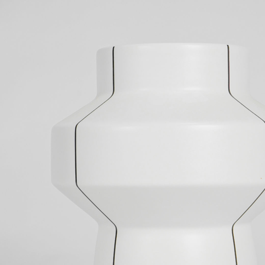 Closeup image of white ceramic geometric vase for modern console table decor with elegant matte finish styling.
