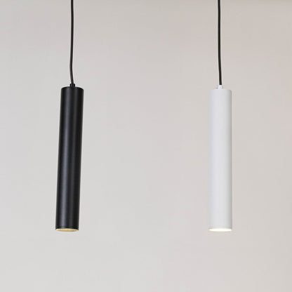 Black tubular pendant light illuminated on a white background highlighting its slim modern cylinder shape.