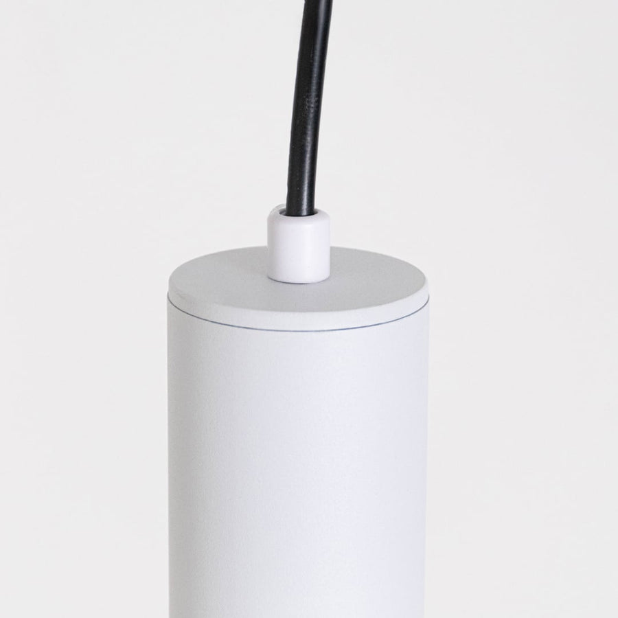 Closeup of white tubular pendant light showing smooth matte finish and elegant slim cylinder design.
