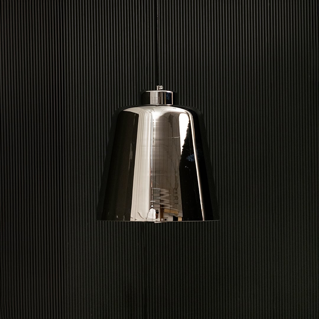 Smoked grey glass pendant light with lights off on black background showing its glossy reflective shade and modern tapered silhouette.