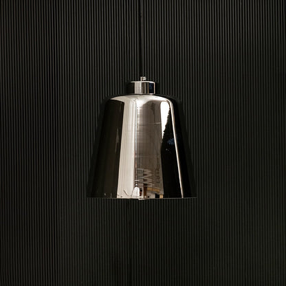 Smoked grey glass pendant light with lights off on black background showing its glossy reflective shade and modern tapered silhouette.