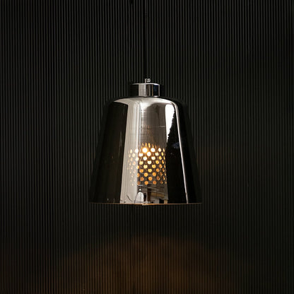 Smoked grey glass pendant light glowing on black background creating a dramatic modern lighting effect with a sleek reflective finish.