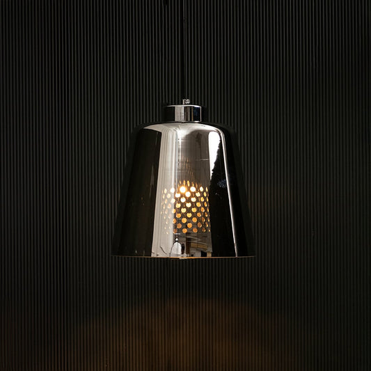 Smoked grey glass pendant light glowing on black background creating a dramatic modern lighting effect with a sleek reflective finish.
