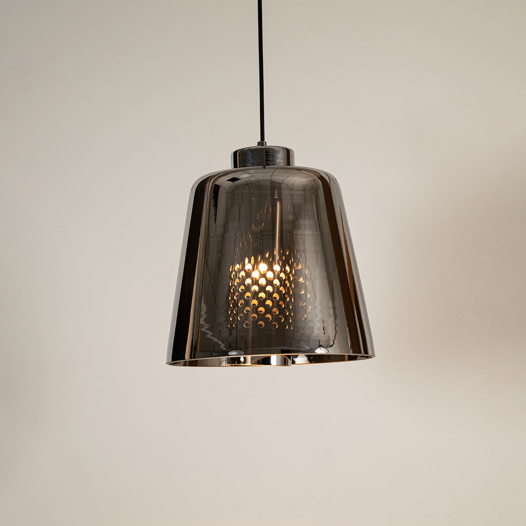 Smoked grey glass pendant light glowing warmly on white background showcasing its modern reflective shade for stylish interior lighting.
