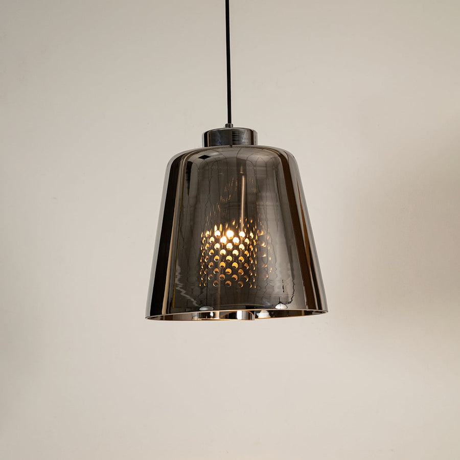 Smoked grey glass pendant light glowing warmly on white background showcasing its modern reflective shade for stylish interior lighting.
