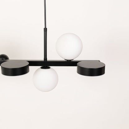 Closeup of black metal chandelier highlighting the smooth white globes and sleek modern frame crafted for premium contemporary interior lighting.