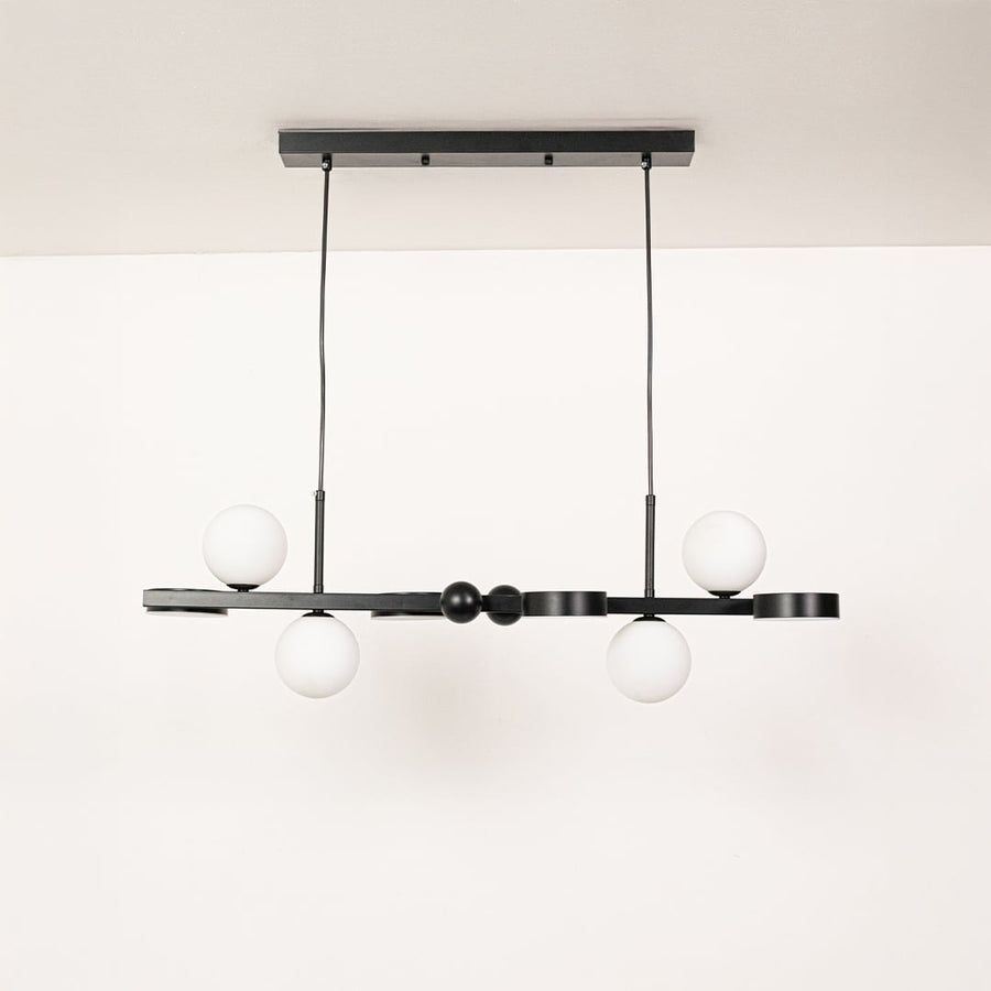 Black metal chandelier with white globe shades displayed with lights off on a clean white background showcasing its modern linear silhouette.