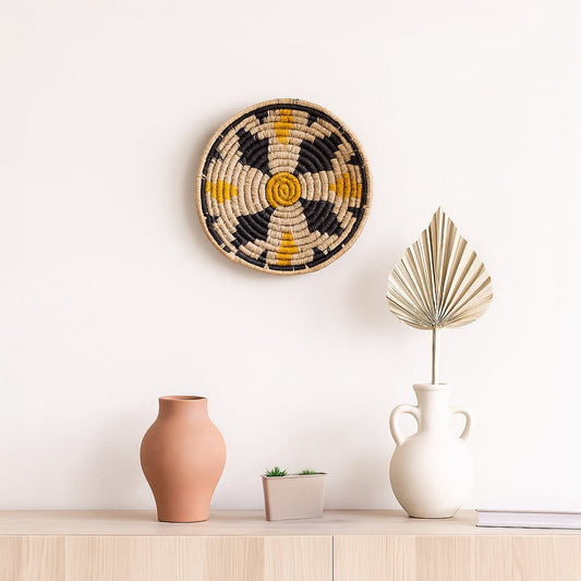 Handwoven round wall basket Decor displayed on a clean white wall above a wooden console with minimal vases creating a calm modern and earthy home styling look.