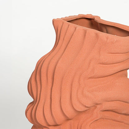 Close up view terracotta sculptural vase showing layered textured surface modern artistic ceramic decor accent.