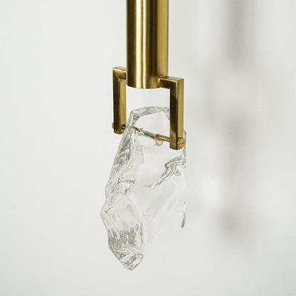 Closeup of gold metal wall light with crystal glass shade for luxury modern lighting decor styling ideas.