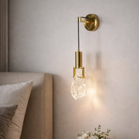 Gold metal wall light with crystal glass shade for elegant modern bedroom lighting and decor styling ideas.