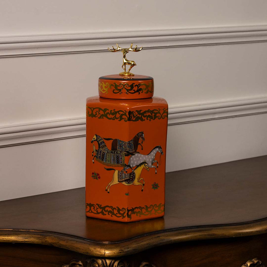 Orange ceramic jar with golden lid and royal horse design handcrafted decor piece for living room styling.