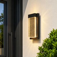 Modern black aluminum rectangular gold textured glass wall sconce on exterior stucco facade for luxury porch lighting decor.