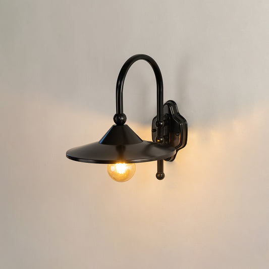 Black metal outdoor wall light on white background with exposed bulb for minimalist exterior lighting decor.