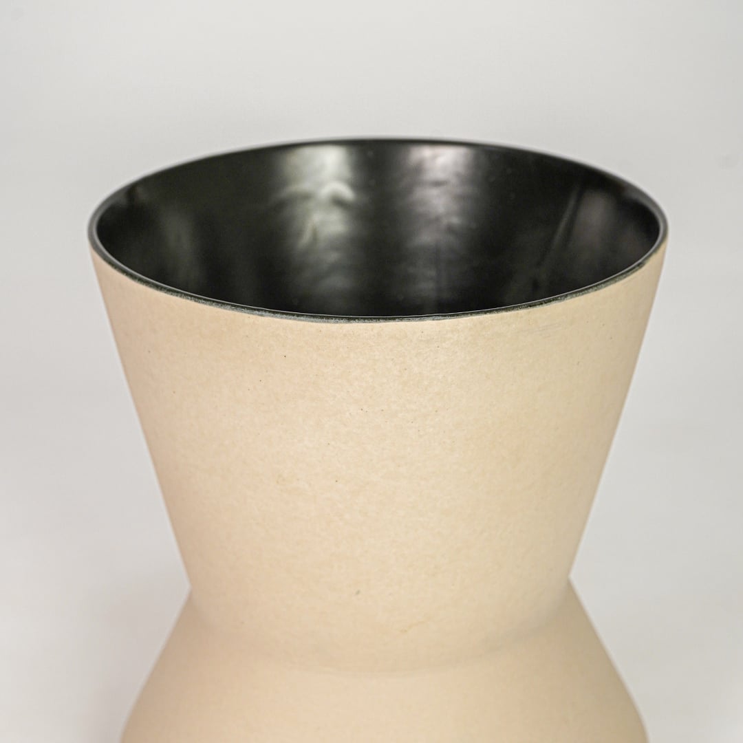 Beige ceramic flower vase closeup with smooth finish modern decorative vase for table console living room decor styling.