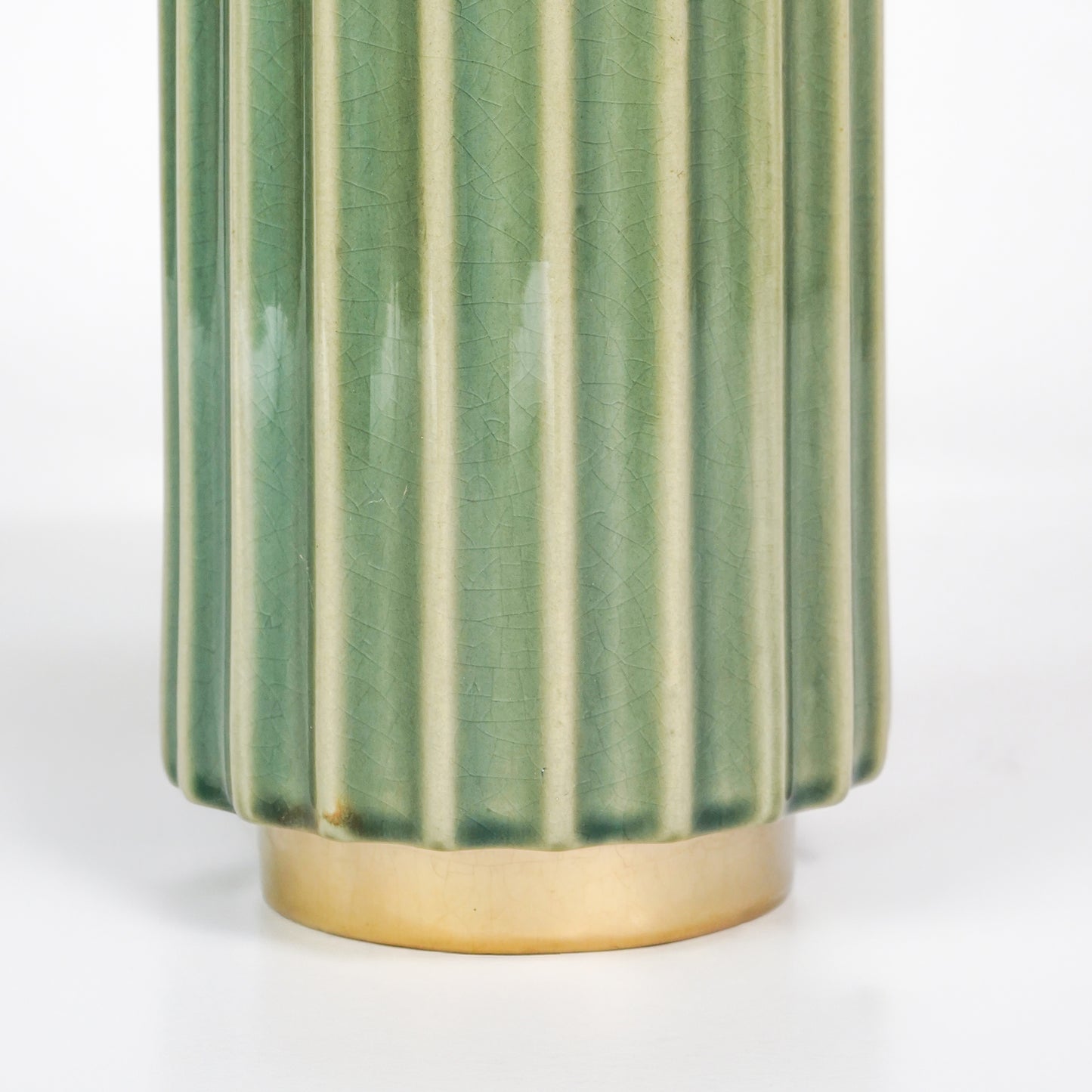 Closeup image of green gold ceramic vase for elegant tabletop decor styling highlighting modern smooth decorative finish.
