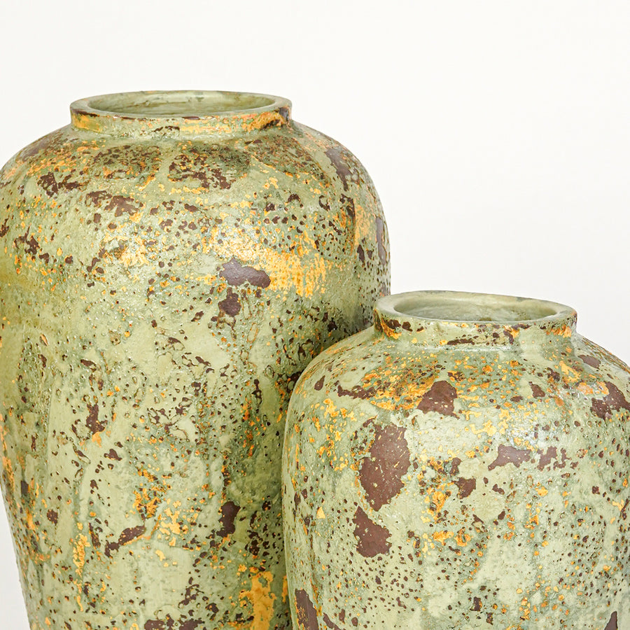 Closeup image of green ceramic decorative vase set for modern living room styling with rustic textured finish.