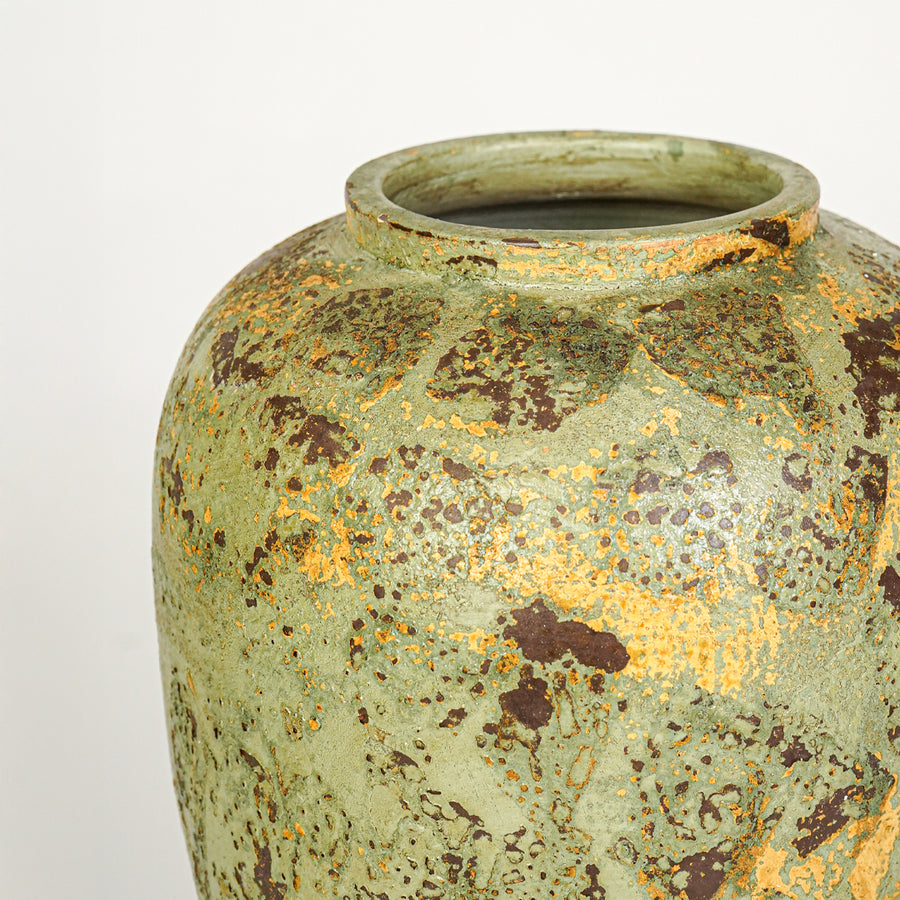Closeup image of green ceramic rustic vase for modern interior decor styling with textured artistic finish.