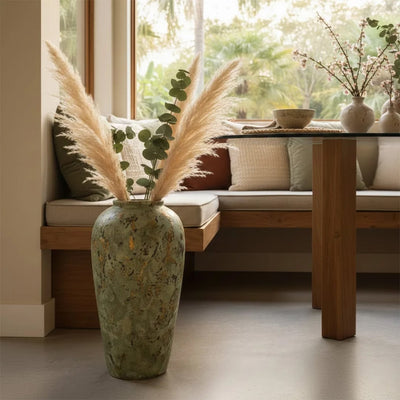 Green textured floor vase with pampas grass placed near window for rustic modern home decor styling.
