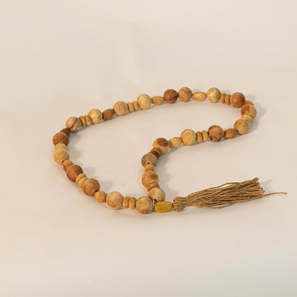 Handcrafted wood bead garland displayed on an off-white background with warm lighting to highlight texture.