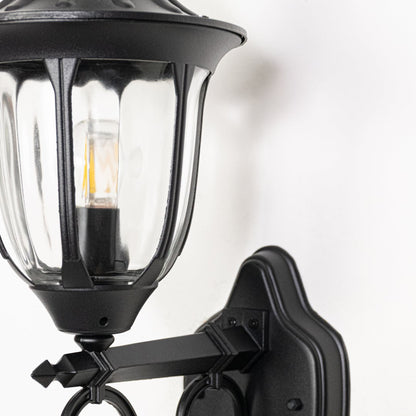 Closeup of black metal outdoor wall light showing textured finish glass detail and durable build designed for exterior wall lighting use.
