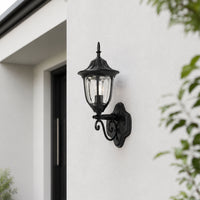 Classic black metal outdoor wall lantern with clear glass for porch entrance garden and exterior walls with warm lighting.