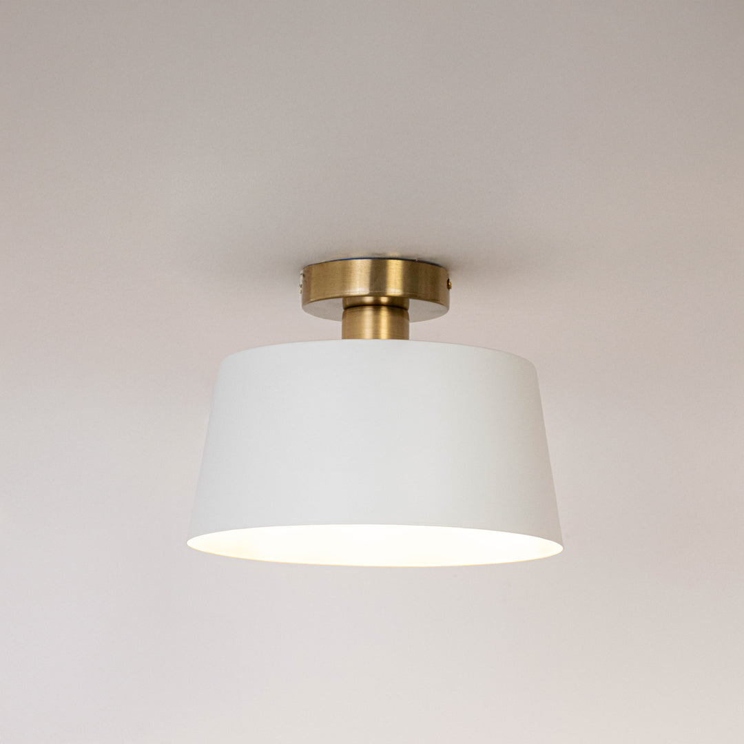Modern white metal ceiling light with soft illumination for elegant hallway and minimalist home decor spaces.