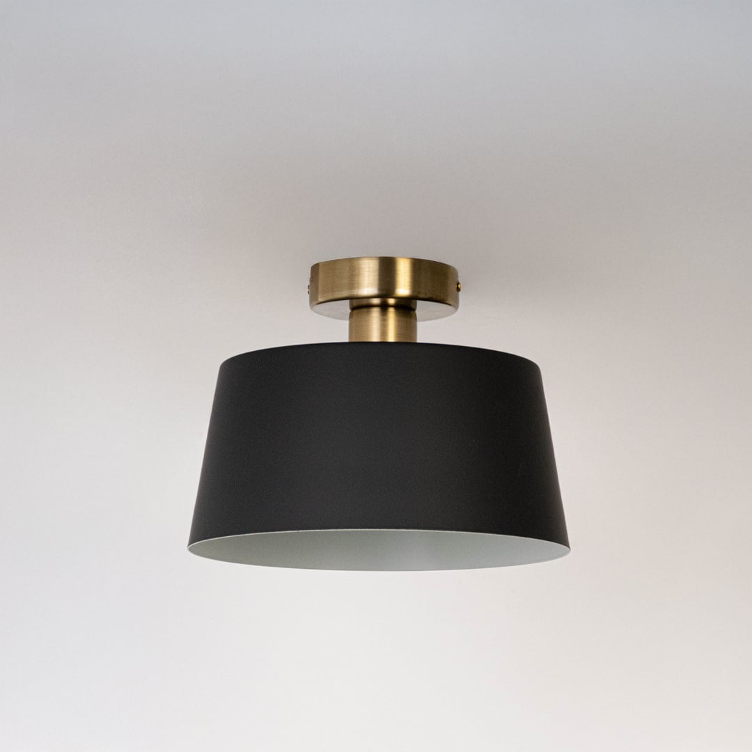 Black ceiling light with gold base and drum shade in off mode displayed on clean white background for stylish ceiling lighting.