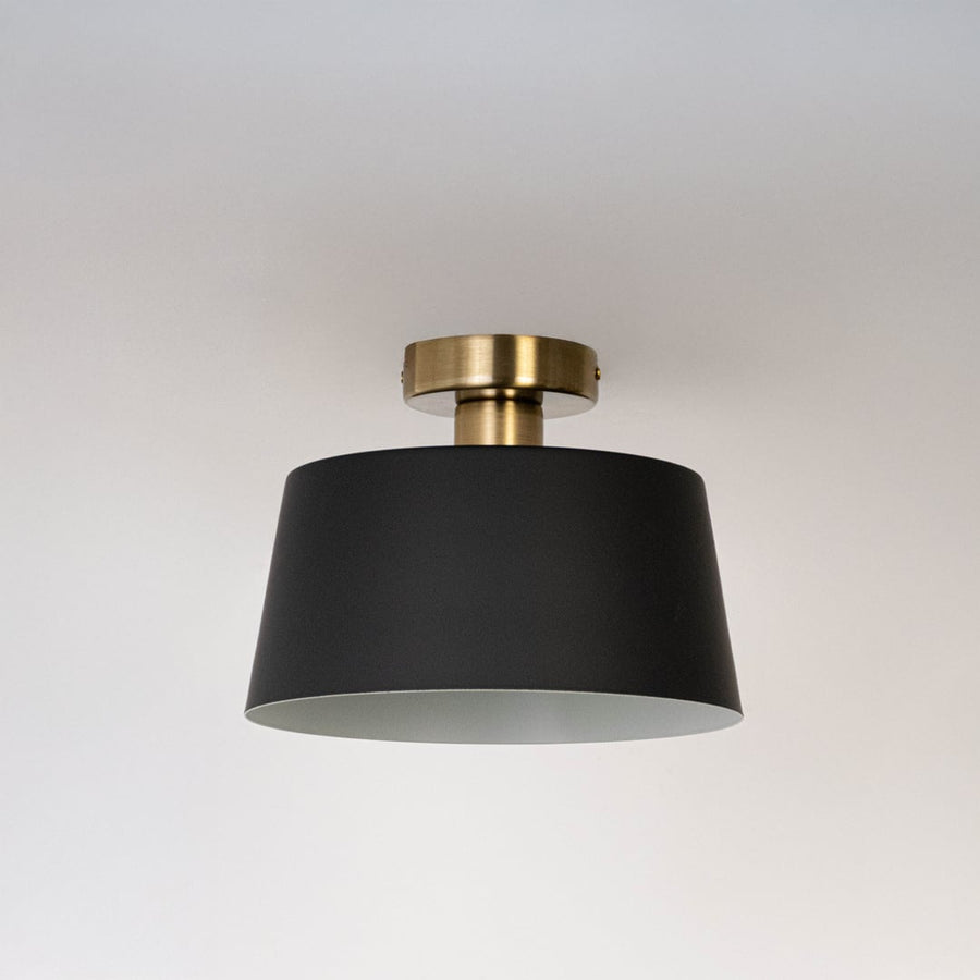 Black ceiling light with gold base and drum shade in off mode displayed on clean white background for stylish ceiling lighting.