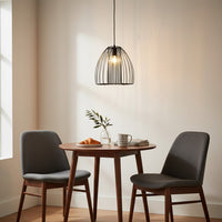 Black metal cage pendant light above dining table creating warm ambient lighting for modern dining room interiors.