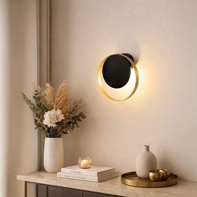 Elegant brass wall light creating warm ambient lighting in modern bedroom and vanity decor.