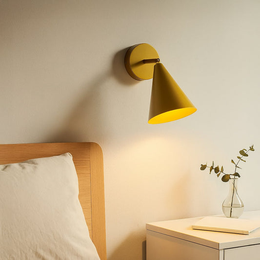 Modern gold wall sconce with a sleek conical metal shade adding warm ambient lighting and creating a stylish contemporary bedroom decor look.